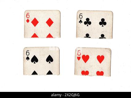 Zerrissene Hälften von Vintage-Spielkarten, die sechs in allen vier Anzügen auf weißem Hintergrund zeigen. Stockfoto
