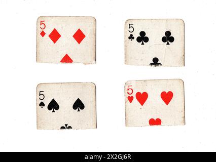 Zerrissene Hälften von Vintage-Spielkarten, die fünf in allen vier Anzügen auf weißem Hintergrund zeigen. Stockfoto