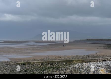 Breiter, weitläufiger Strand am Westufer, Walney Island, Barrow-in-Furness, Cumbria, unter grauem stürmischem Himmel mit Black Combe Mountain im Hintergrund. Stockfoto