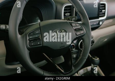 Fahrzeuginnenraum mit Logo Hyundai. Neues Autolenkrad. Elegante Oldtimer-Steuerplatine. Hyundai-Emblem am Lenkrad. Teil des Fahrzeugs. Stockfoto