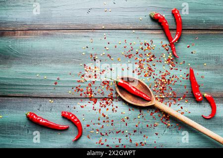 Rote, scharfe Cayennepfeffer, sowohl frisch als auch getrocknet, in Holzlöffel. Flach über rustikalem Hintergrund. Stockfoto