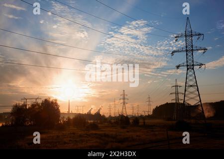 Hochspannungs-Übertragungstürme in den Vororten bei Sonnenaufgang Stockfoto