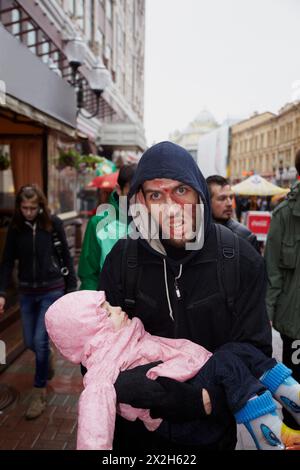 MOSKAU - 14. MAI: Unbekannter Teilnehmer mit schlafendem Baby in den Armen bei der Zombie-Parade auf Old Arbat, 14. Mai 2011, Moskau, Russland. Stockfoto