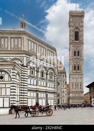 Florenz, Italien - 4. April 2024: Piazza San Giovanni mit Pferdekutsche für Touristen in der Nähe des Baptisteriums und mit dem Glockenturm von Giotto im Backgro Stockfoto