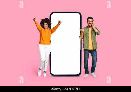 Enthusiastisches Multirassisches Paar mit Smartphone-Bildschirm-Mockup Stockfoto