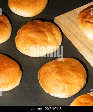 Frisch gebackenes rundes Brötchen isoliert, runde Brötchen auf einem kahlen und hölzernen Hintergrund. Stockfoto