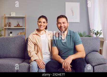 Glückliches Junges Paar Porträt, Das Zu Hause Auf Dem Sofa Sitzt Stockfoto