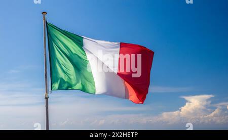 Die Fahne von Italien flattert im Wind, isoliert gegen blauer Himmel Stockfoto