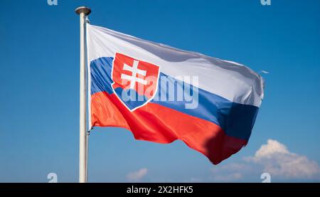 Die Fahne von der Slowakei flattert im Wind, isoliert gegen blauer Himmel Stockfoto
