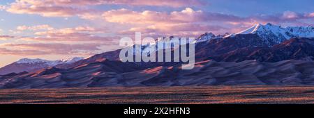 Das Golden Hour Licht erwärmt die Gipfel der Sangre de Cristo Mountains und die Gipfel der Dünen im Great Sand Dune National Park, Colorado Stockfoto