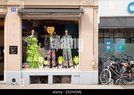 Basel, Schweiz - 18. April 2024: Stadtstraße mit Mode-Boutique schönes Apfelgeschäft und geparkten Fahrrädern Stockfoto