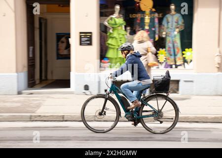 Basel, Schweiz - 18. April 2024: Eine Frau fährt Fahrrad auf der Stadtstraße Stockfoto