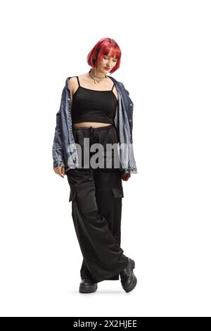 Junge Frau mit rotem Heair, die schwarze breite Hose und Jeanshemd auf weißem Hintergrund trägt Stockfoto