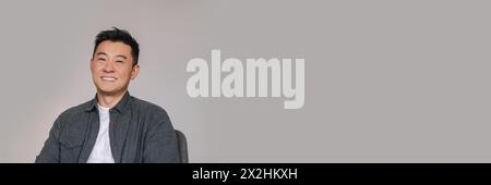 Porträt eines gutaussehenden reifen asiatischen Mannes auf grauem Hintergrund Stockfoto