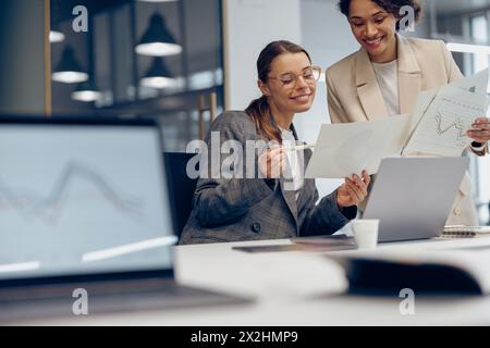 Zwei weibliche Experten für professionelle Führungskräfte diskutieren über die Zusammenarbeit mit Finanzbuchhaltungsunterlagen Stockfoto