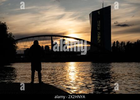 22. April 2024, Hessen, Frankfurt/Main: Ein Mann beobachtet den Sonnenuntergang am Main in Frankfurt. Es wird erwartet, dass das Wetter in den kommenden Tagen kühl und regnerisch bleibt. Foto: Boris Roessler/dpa Stockfoto