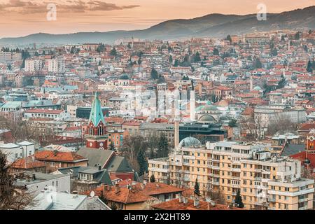 Der hoch aufragende Glockenturm der Kirche Saint Anthony, der sich in Richtung Himmel inmitten der Skyline von Sarajevo erstreckt. Stockfoto