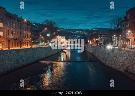 14. März 2024, Sarajevo, Bosnien und Herzegowina: Lateinische Brücke: In der Abenddämmerung spiegelt der Fluss den historischen Charme der Stadt wider Stockfoto