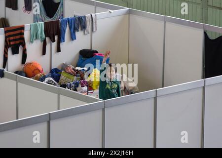 Flüchtlingskinder schauen am 9. Dezember 2015 im ehemaligen Hangar von Tempelhof über die Wand eines provisorischen Zimmers in einem Notunterstand für Flüchtlinge Stockfoto