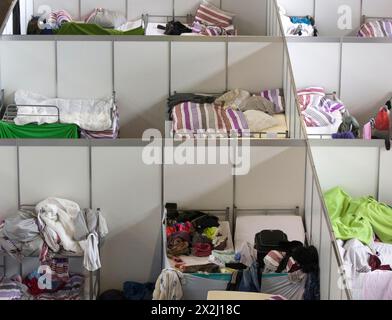 In einem ehemaligen Hangar am Flughafen Tempelhof, Berlin, werden am 9. Dezember 2015 provisorische Zimmer mit Betten in einer Notunterkunft für Flüchtlinge eingerichtet Stockfoto