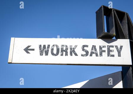 Arbeitssicherheit. Weißer Wegweiser und blauer Himmel. Stockfoto