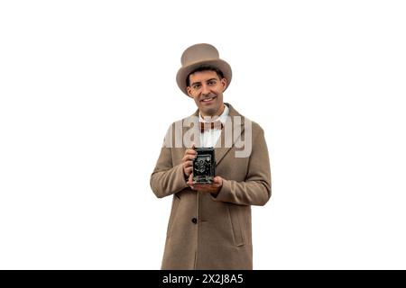 Vintage-Fotograf aus dem frühen 20. Jahrhundert, mit Bowler-Hut und Trenchcoat, fotografiert mit einer klassischen antiken Kamera Stockfoto