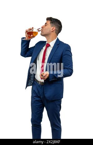 Vertikaler Geschäftsmann, der sich in einem Anzug mit einem Getränk aus einer Flasche Alkohol verwöhnt. Ein Moment der Entspannung inmitten der Unternehmenswelt Stockfoto