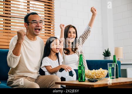 Eine glückliche Familie genießt den Nervenkitzel eines Fußballspiels zu Hause Stockfoto