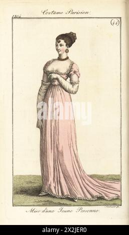 Junge Pariser Frau in Niobe geflochtener Frisur, transparentem, tiefgeschnittenem Musselin-Kleid über rosa Taft-Unterrock. Pl. 587 in der Pariser Ausgabe. Kostüm d'une Jeune Personne. Coeffure en cheveux a la Niobe, Robe de Mousseline claire. Handkolorierter Kupferstich von Friedrich Ludwig Neubauer aus Pierre de la Messengere’s Journal des Dames et des Modes, Francfort sur le mein (Frankfurt) 1804. Nach Illustrationen von Carle Vernet, Jean-Francois Bosio, Dominique Bosio und Philibert Louis Debucourt. Stockfoto