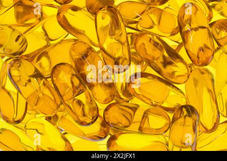 Omega 3 Fisch Krill Öl Kapseln Ergänzungen verstreut Gesundheit Gelbgold hinterleuchtet. Stockfoto