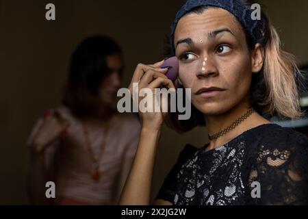 Ein junger Transgender-Mann (26) ist in seinem Zimmer und trägt Make-up auf. Transgender-Konzept Stockfoto