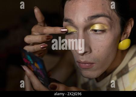 Junger Transgender-Mann (22) ist in seinem Zimmer und trägt Make-up auf. Transgender-Konzept Stockfoto