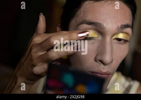 Junger Transgender-Mann (22) ist in seinem Zimmer und trägt Make-up auf. Transgender-Konzept Stockfoto