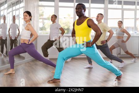 afroamerikaner mittleren Alters, der Beinübungen in der Trainingshalle macht Stockfoto