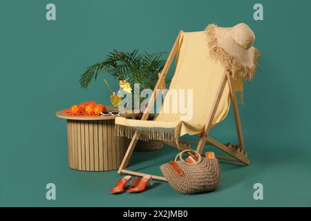 Liegestuhl, Strandaccessoires, Glas Cocktail und Orangen auf farbigem Hintergrund Stockfoto