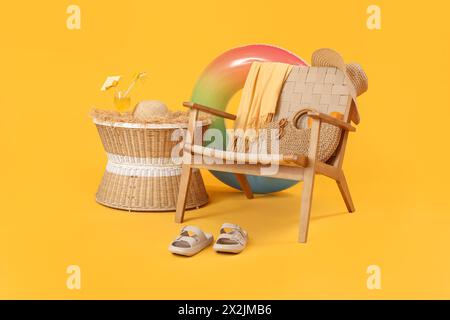 Sessel mit Strandaccessoires und ein Glas Cocktail auf dem Tisch vor farbigem Hintergrund Stockfoto