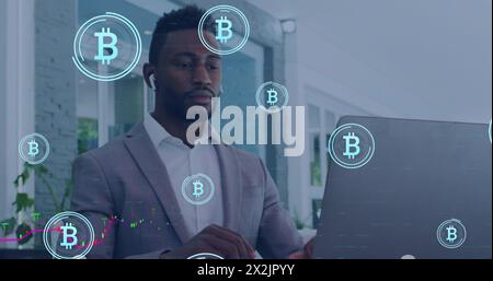 Bild von Datenverarbeitung und Bitcoin-Symbolen über afrikanischem amercian-Geschäftsmann mit Laptop Stockfoto
