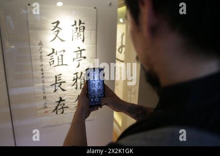 Mexiko-Stadt, Mexiko. April 2024. Ein Mann fotografiert chinesische Kalligraphie bei einer Kalligraphie-Ausstellung in Mexiko-Stadt, Mexiko, am 20. April 2024. Quelle: Francisco Canedo/Xinhua/Alamy Live News Stockfoto