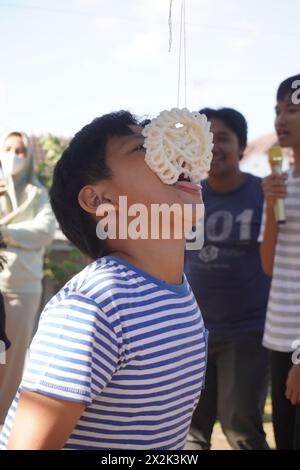 Kinder nehmen an einem Cracker-Ess-Wettbewerb zum Gedenken an Indonesiens Unabhängigkeitstag Teil Stockfoto