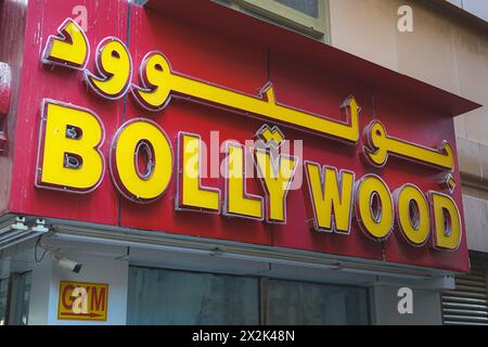 Helles und auffälliges Bollywood-Schild in leuchtenden Rot- und Gelbtönen über einem Eingang des Fitnessstudios in einer belebten städtischen Umgebung, das Kultu zeigt Stockfoto