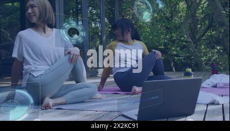 Bild der Datenverarbeitung über asiatische Mutter und Tochter mit Laptop, der Yoga übt Stockfoto