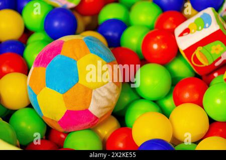 Farbenfroher Soft Ball und Spielzeugwagen in einer Pit of Plastic Balls auf einem Indoor Spielplatz Stockfoto