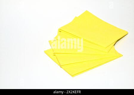 Auf weißem Hintergrund befinden sich gelbe Viskoseservietten zum Entfernen von Staub, Feuchtigkeit und Schmutz. Stockfoto