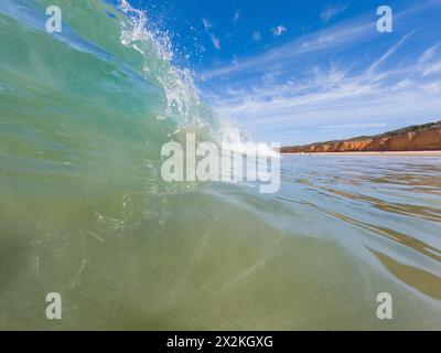 Niedriger Winkel auf den Kamm einer Welle, die in flachem Wasser stürzt, am Point Roadknight an der Great Ocean Road in Victoria, Australien Stockfoto