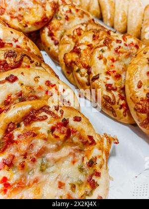 Frisch gebackene Mini-Pizzen mit geschmolzenem Käse und roter Paprika darüber Stockfoto