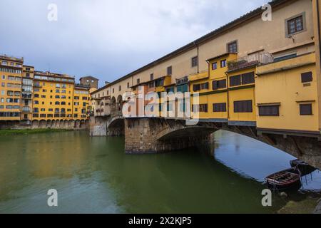 Ponte Vecchio über den Fluss Arno im Zentrum von Florenz in der Toskana, Italien. An einem bewölkten Morgen mit klassischem Blick auf die Geschäfte und Fenster. Stockfoto