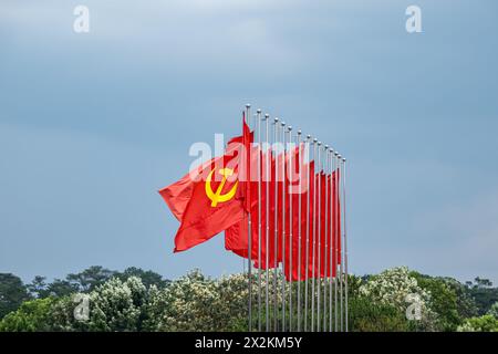 Große kommunistische Flagge, die im Wind schwimmt, mit blauem Himmel Hintergrund. Rote sowjetische Flagge winkt am windigen Tag in Asien, Vietnam Stockfoto