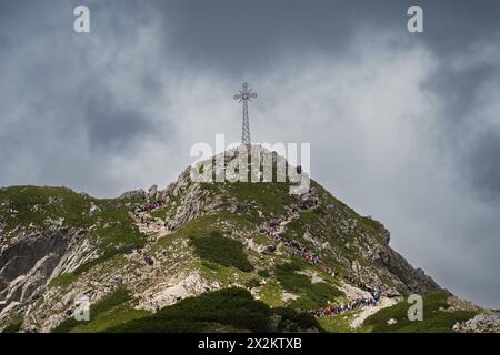 Polen, Zakopane 25. Juli 2023. Menschen strömen mit dem Giewont-Kreuz auf den hohen Berg. Der Himmel ist bewölkt. Stockfoto