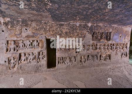 Ellora buddhistische Höhlen: Höhle Nr. 11 im zweiten Stock – intrusive Platte links von einem unvollständigen Schrein, gegenüber dem Hauptschrein zeigt sitzende Buddha-Bilder Stockfoto