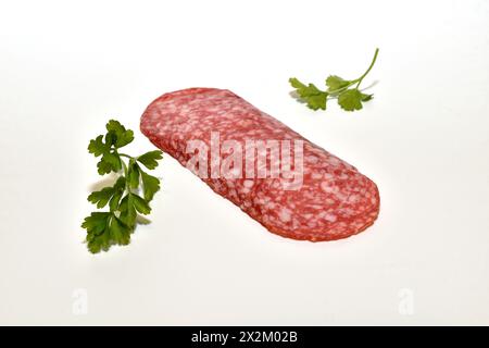 Dünn geschnittene Wurst liegt in einer Reihe auf weißem Hintergrund. Stockfoto